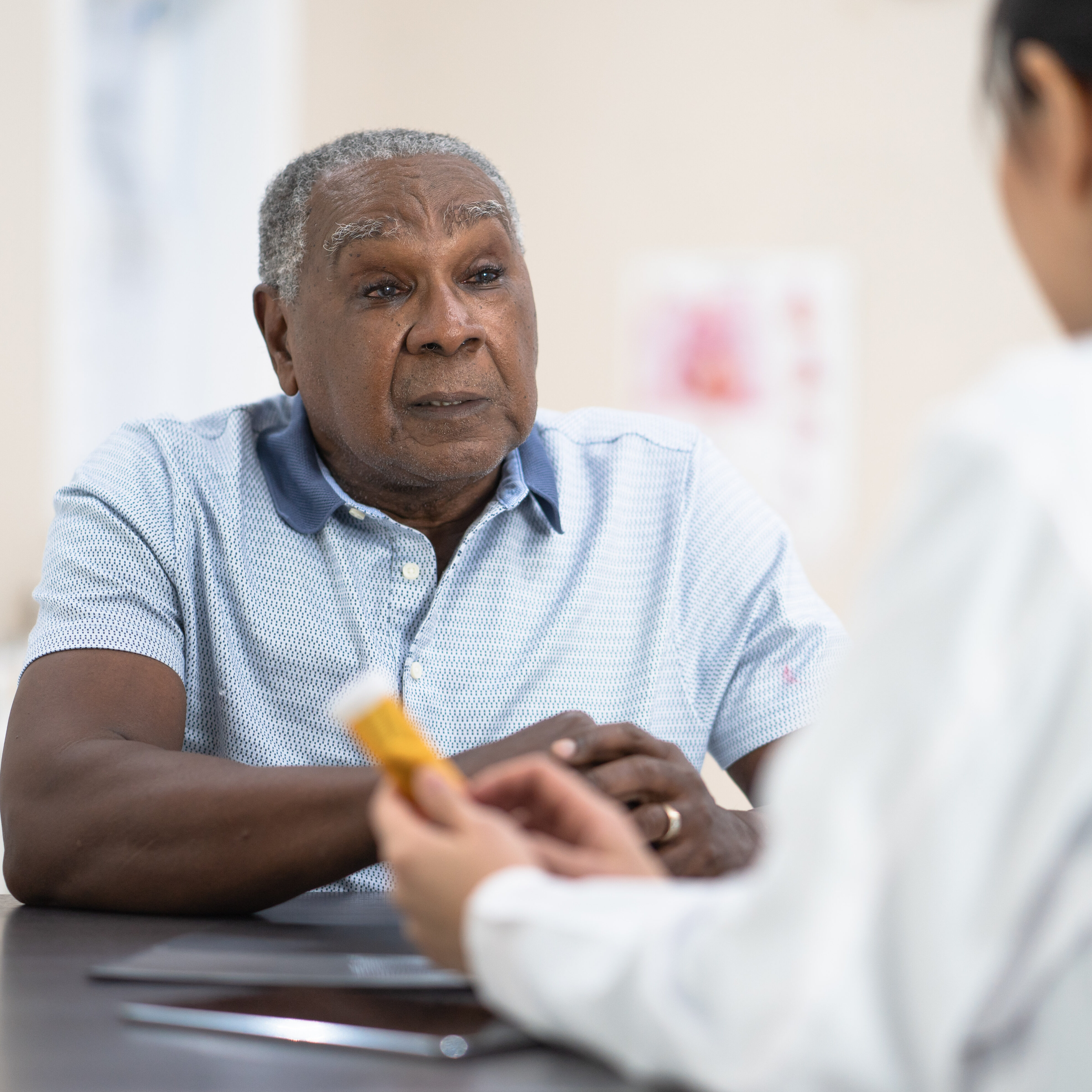 A senior man of african descent listens to his female doctor.